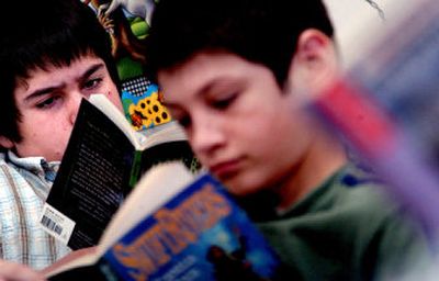 
Sandpoint Middle School eighth-grader Jimmy Aylward, left, reads during free reading time Tuesday morning. The school has received a $437,000 grant from the Panhandle Alliance for Education and is developing a new reading program that will start in the fall. 
 (Kathy Plonka / The Spokesman-Review)