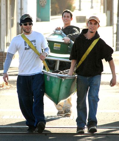 Isik Best, Micah Robinson and Raymond Woods haul their canoe through the streets of downtown in Lewiston, Idaho, Thursday, Jan. 21, 2010, to the Clearwater River so Best could go fishing while Woods and Robinson man the paddles. (Barry Kough / Lewiston Tribune)