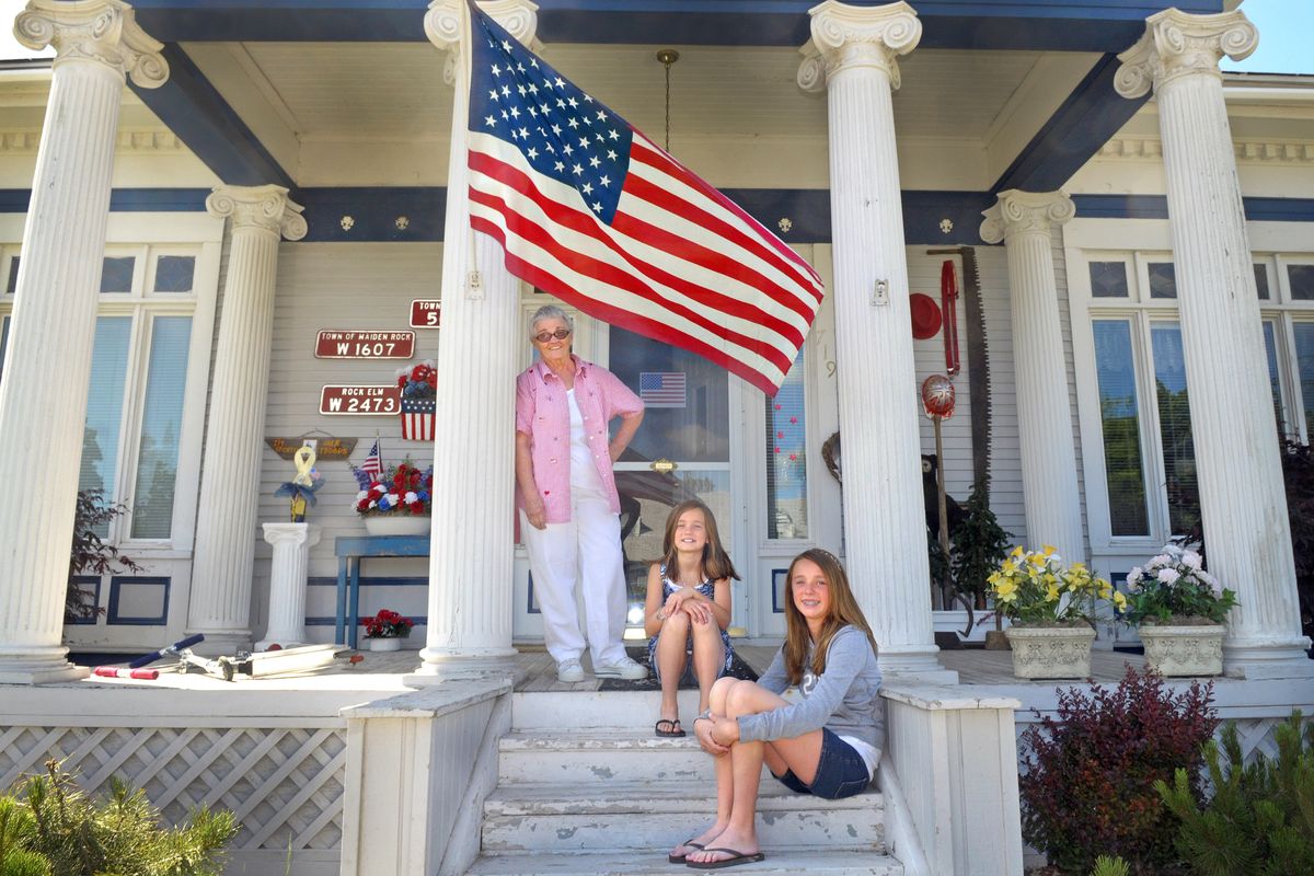 Bernice Jackson Leavitt, back left, stands under the American flag on the front porch of her Davenport Wash. home visiting with her granddaughters Kyra Arland, front, and Hailey Arland, center, on Wednesday June 29, 2011. (Christopher Anderson / The Spokesman-Review)