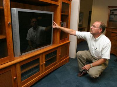 
Stan Short, executive assistant of merchandising of Sauder Woodworking Co., adjusts a prop large-screen television on a display entertainment center at Sauder's Archbold, Ohio, headquarters on Aug. 9. Larger television screens have prompted furniture manufacturers to enlarge their offerings. 
 (Associated Press / The Spokesman-Review)