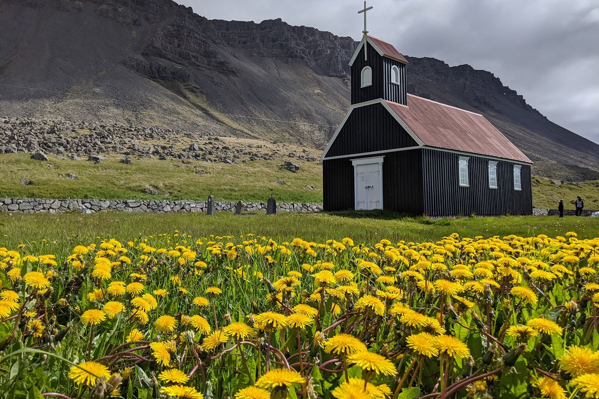 Painted a striking black, Saurbaer Church overlooks the red-sand Raudasandur beach.  (Jen Rose Smith/For the Washington Post)