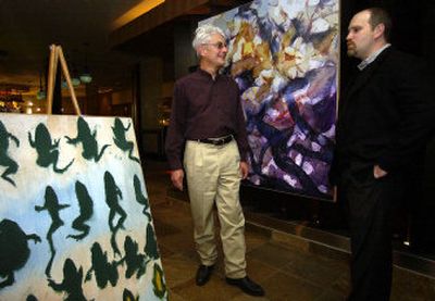Local artist Ralph Busch, left, and Dennis Manley discuss the placement of Busch's paintings for First Wednesday at Mac Restaurant in the Mirabeau Park Hotel in Spokane Valley. The painting at left is