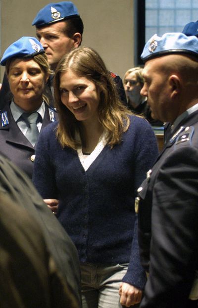 U.S. murder suspect Amanda Knox, center, reacts as she is escorted inside a courtroom to stand trial, in Perugia, Italy, on Feb. 13, 2009. An American student charged with the murder of her British roommate showed no distress and was cuddling with her boyfriend hours after the slaying, a friend of the victim testified. Robyn Carmel Butterworth told the packed courtroom in this Umbrian university town that she was among several students waiting to talk to officers in Perugia's police station shortly after Meredith Kercher's bloodied body was found. (Associated Press)