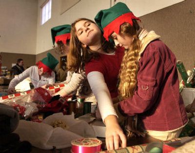 
Greenacres Middle School  students Victoria Rybalko, left,  and Brittney Thomas   wrap packages with their Spirit Service Club at the 12th annual Season of Sharing gift-giving program Tuesday at the Spokane Valley United Methodist Church. 
 (J. BART RAYNIAK / The Spokesman-Review)