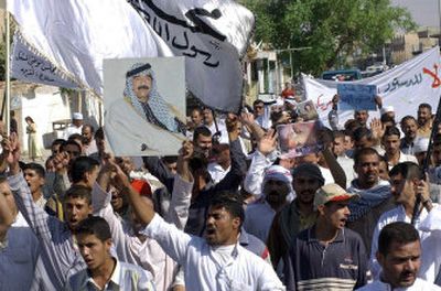 
Protesters rally carrying banners and pictures of ousted Iraqi leader Saddam Hussein, in Tikrit on Monday. Thousands of Sunni Arabs demonstrated in Saddam Hussein's former hometown to denounce Iraq's new constitution a day after negotiators finished the new charter without the endorsement of Sunni Arabs. 
 (Associated Press / The Spokesman-Review)