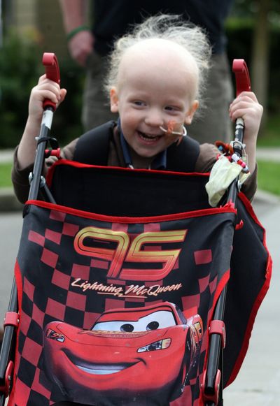 John Hartle, 3, from Kalispell, Mont., pushes his stroller Saturday in Seattle, where he’s receiving chemotherapy treatments.  (Alan Berner)