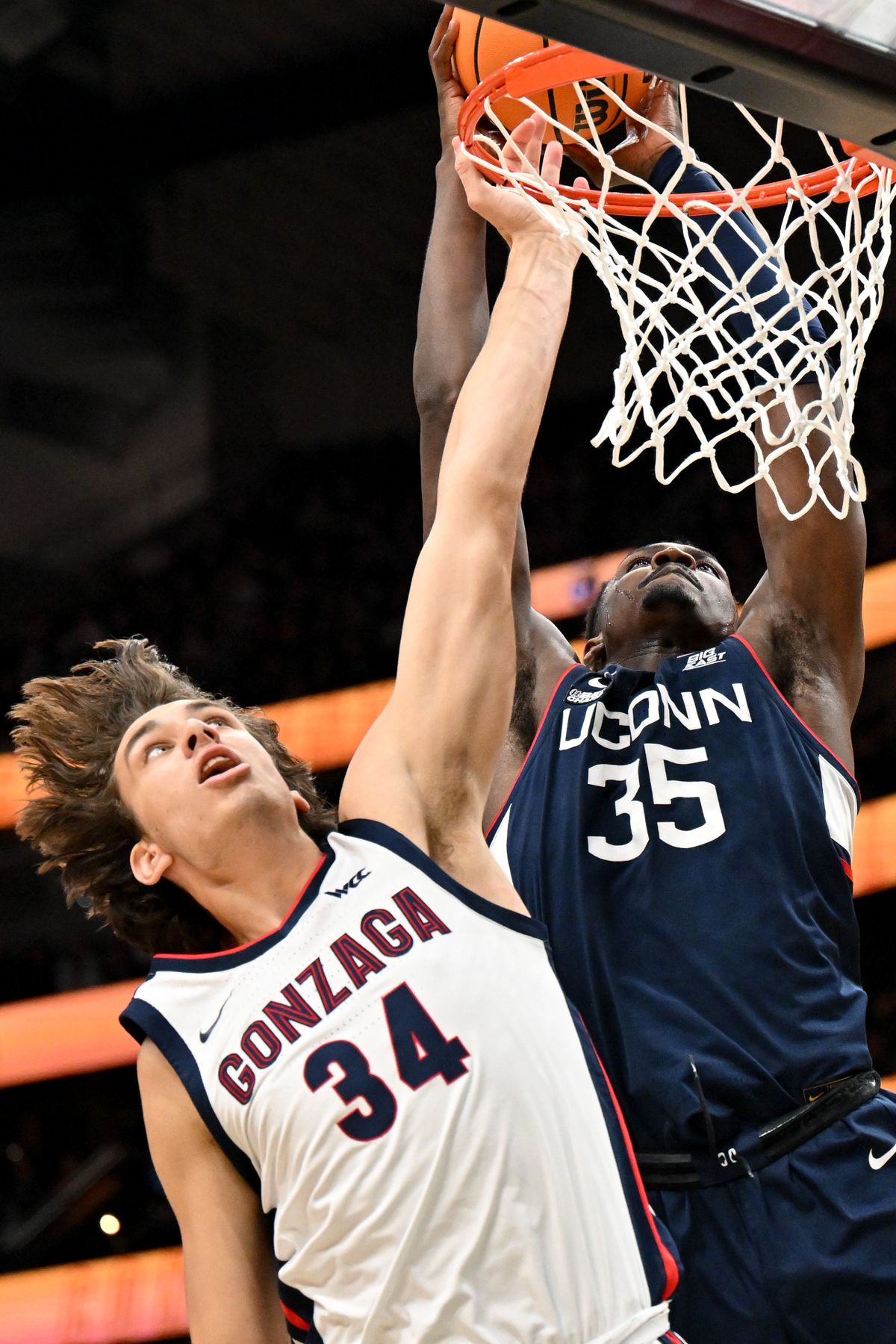 Connecticut forward Samson Johnson dunks against Gonzaga forward Braden Huff during the first half of Friday’s Seattle Tip-Off at Climate Pledge Arena in Seattle.  (Tyler Tjomsland/The Spokesman-Review)