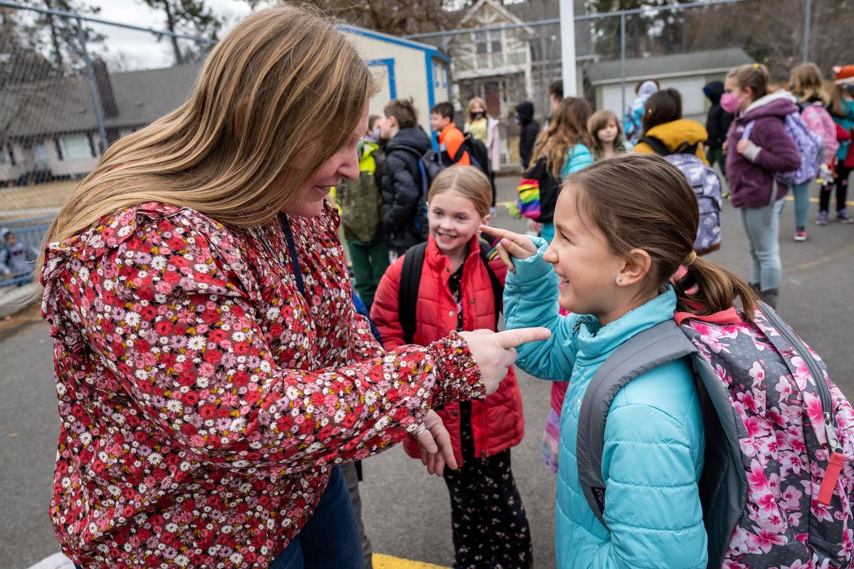 “I can see all your beautiful faces,” said Roosevelt second-grade teacher Amy Krauss to her student, Maggie Byrne, 8, who was lining up with maskless classmates outside the school Monday. It’s been almost two years since the school day was anything but normal, but finally masks are optional at Spokane Public Schools.  (COLIN MULVANY/THE SPOKESMAN-REVIEW)