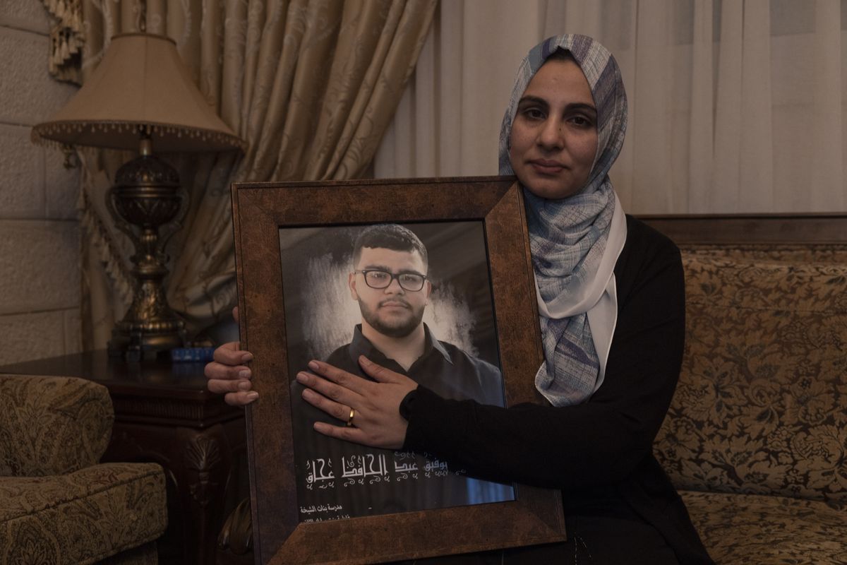Mona Abdel Jabbar sits with a photograph of her late son, 17-year-old Tawfic Abdel Jabbar, at her home in the West Bank on Wednesday.    ( Heidi Levine/for The Washington Post)