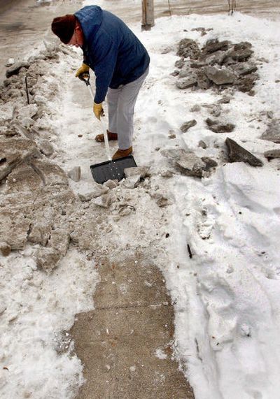 
Steve Schauer clears the sidewalk in front of his Coeur d'Alene home Monday.
 (Kathy Plonka / The Spokesman-Review)