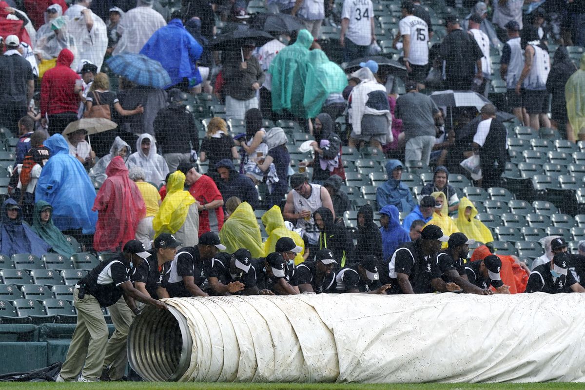 The Chicago White Sox grounds crew puts a tarp on the field during a rain delay in the third inning of a baseball game against the Seattle Mariners in Chicago, Saturday, June 26, 2021.  (Associated Press)