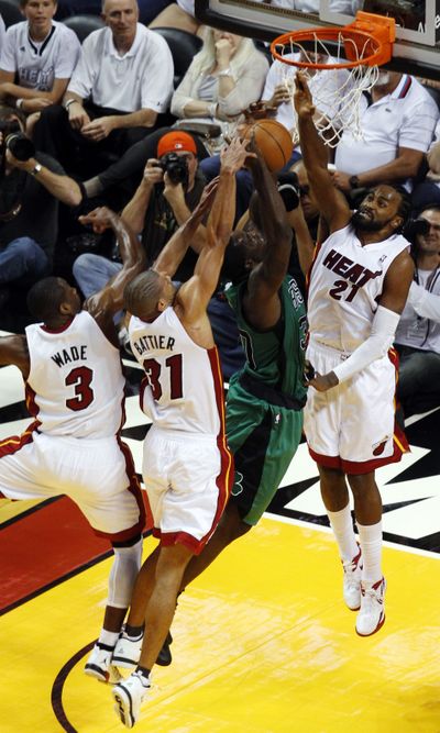 Miami’s Ronny Turiaf (21), Dwyane Wade (3) and Shane Battier (31) defend against a shot by Boston Celtics' Brandon Bass. (Associated Press)