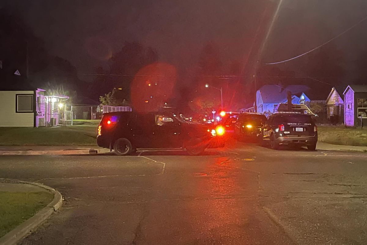 Police officers close the intersection of Crown Avenue and Cincinnati Street in northeast Spokane early Wednesday morning as they investigate a shooting.   (Garrett Cabeza / The Spokesman-Review)