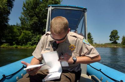 
Zirker  finishes paperwork Saturday on Lake Coeur d'Alene after writing tickets.
 (The Spokesman-Review)