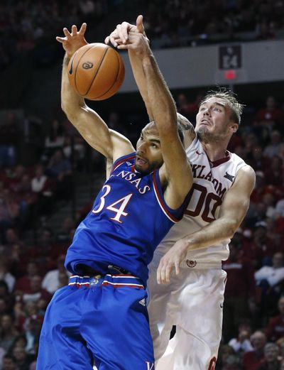 Oklahoma forward Ryan Spangler, right, fouls Kansas’ Perry Ellis as he reaches for a rebound. (Sue Ogrocki / Associated Press)