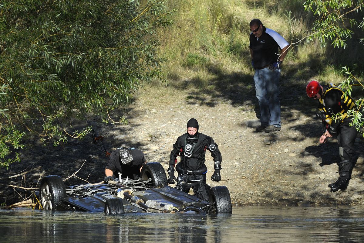 Spokane County Sheriff’s dive team members, with the help of tow truck operators, recover a car from the Spokane River with three bodies inside on Wednesday. Spokane police believe the bodies were those of three Bhutanese refugees missing for several weeks. (Colin Mulvany)
