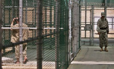 
In this Sept. 2006 file photo, a detainee, left, walks laps around  an excercise area at the Guantanamo Bay U.S. Naval Base, Cuba. 
 (Associated Press / The Spokesman-Review)