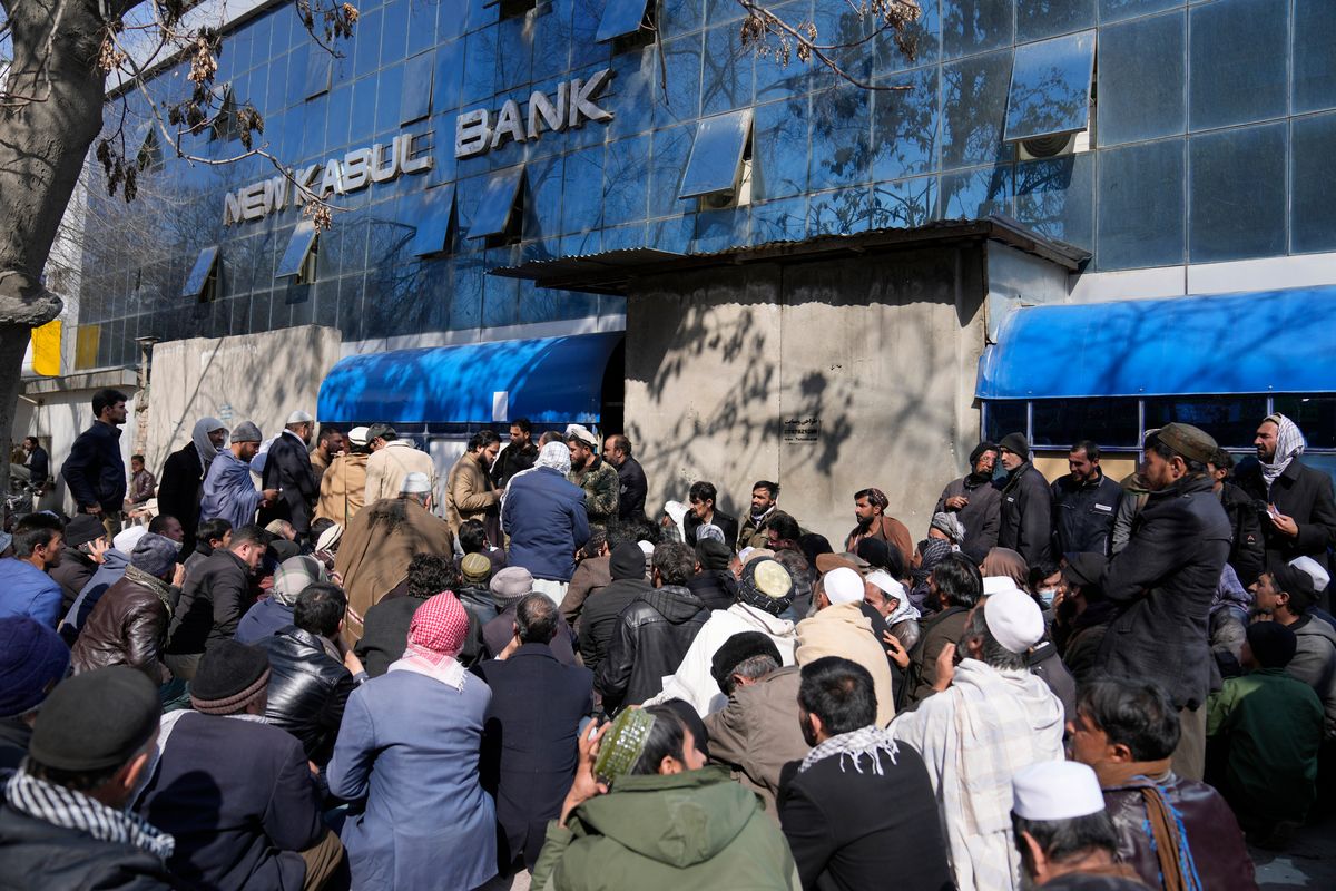 Afghan wait to enter a bank, in Kabul, Afghanistan, Sunday, Feb. 13, 2022. Six months since Kabul was ceded to the Taliban with the sudden and secret departure of U.S.-backed president residents say a calm has settled on the country, but the future is uncertain as the economy teeters on the verge of an economic collapse and the new Taliban rulers tackle the transition from war to relative peace. (Hussein Malla)