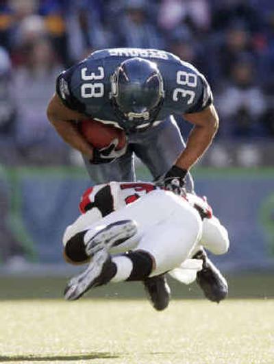 
Seattle's Matt Strong catches a pass before being upended by Atlanta's Jason Webster.
 (Associated Press / The Spokesman-Review)