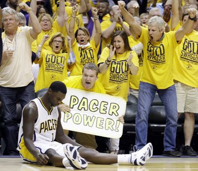 Pacers fans react after Lance Stephenson, sitting, hit a shot against Miami as time expired in the third quarter. (Associated Press)