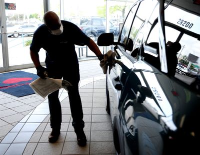 An Avis Ford employee polishes a 2021 Ford Bronco Sport on June 8, 2021, at the car dealership in Southfield, Mich.  (Eric Seals/Detroit Free Press)