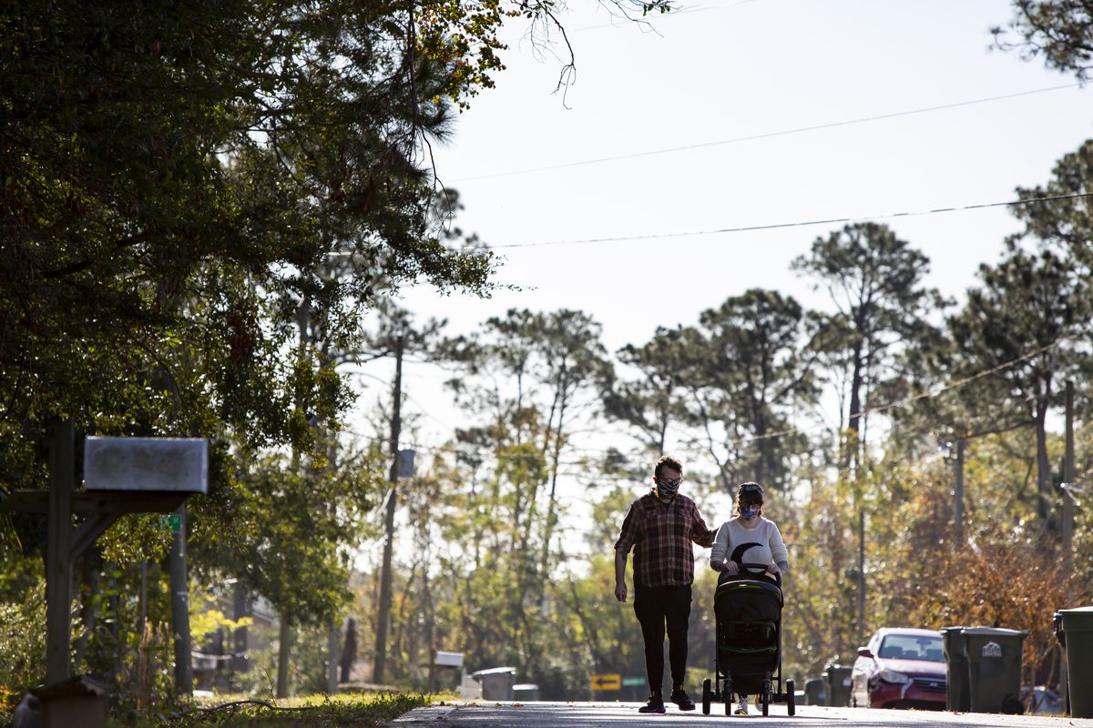 Katy Dobson and Aaron Walker take a walk with their son, Atlas, near their home in Pensacola, Fla., on Dec. 23. Atlas was conceived in the early days of the coronavirus pandemic and was born Dec. 8.  (Meggan Haller/For the Washington Post)