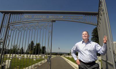 Greg D. Ridgley stands at the  gate he built for the  Fort George Wright Cemetery. (Christopher Anderson / The Spokesman-Review)
