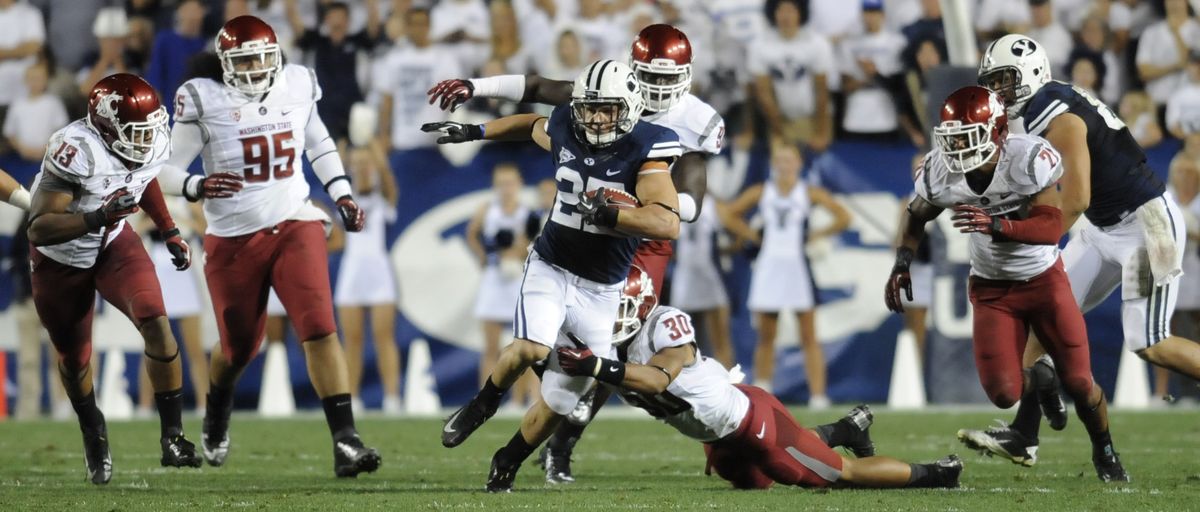 The Washington State defense tries to get a handle on BYU wide receiver Kurt Henderson in the first half. (Tyler Tjomsland)