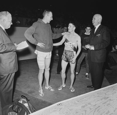 Phil Shinnick of Washington, left, his leg taped, congratulates Spokane’s Gerry Lindgren on winning the two-mile event in the San Francisco Holiday Invitational track meet on Dec. 28, 1963. Shinnick won the broad jump with a leap of 25-feet 6½ inches. Lindgren, of Rogers High School, carded 9 minutes flat for the two-mile.  (Associated Press)