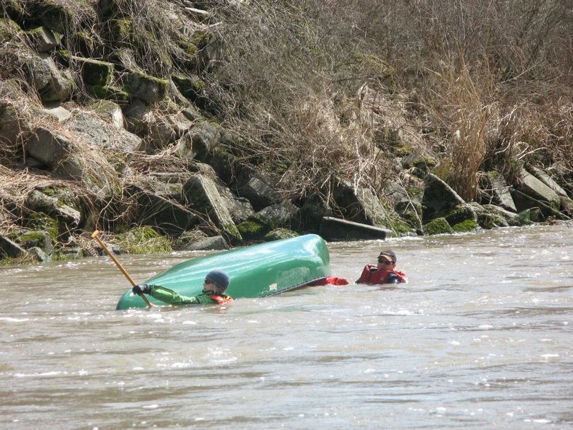 Dan Hansen and  Therese Wittman were glad there was a an air bladder in the canoe when they tipped over while surfing a wave on Hangman Creek. The air bag helped keep the boat on top of the water and easy to work it to shore. (Julie Titone)