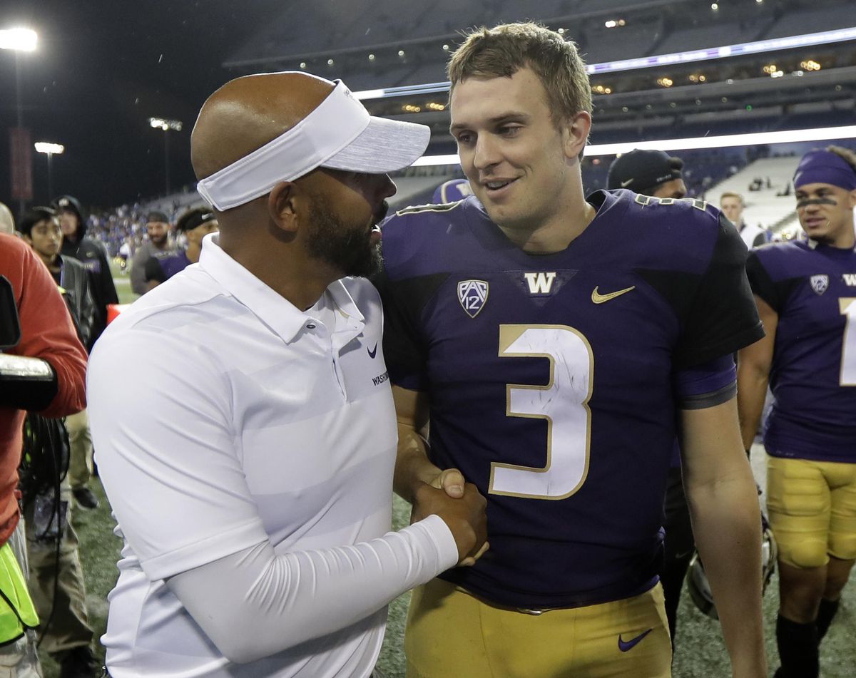 Washington quarterback Jake Browning (3) shakes hands with Defensive Coordinator Jimmy Lake, left, following an NCAA college football game against BYU, Saturday, Sept. 29, 2018, in Seattle. Washington won 35-7. (Ted S. Warren / AP)