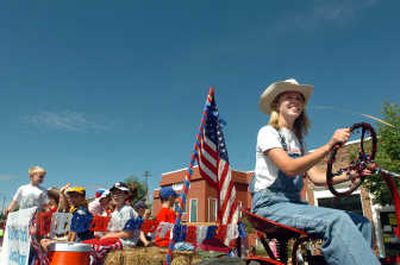 
Kim Cox drives the tractor pulling a wagon for children in the parade entry from the Church of Jesus Christ of Latter-day Saints in the Rathdrum Days parade Saturday. 
 (Photos by JESSE TINSLEY / The Spokesman-Review)