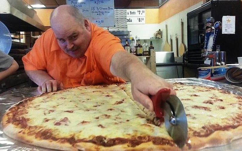 Nate's New York Pizza owner Glenn Gatherer sections off one of the restaurant's 36-inch pizzas. Nate's is open Wednesday through Sunday. (Courtesy photo via Coeur d'Alene Press)