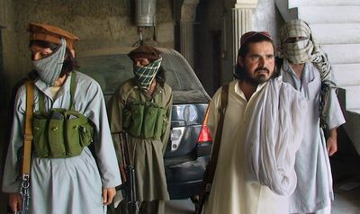 Qari Zainuddin, the leader of a Taliban faction, accompanied by his bodyguards, pauses outside his office  in Dera Ismail Khan, Pakistan, earlier this month.  (Associated Press / The Spokesman-Review)