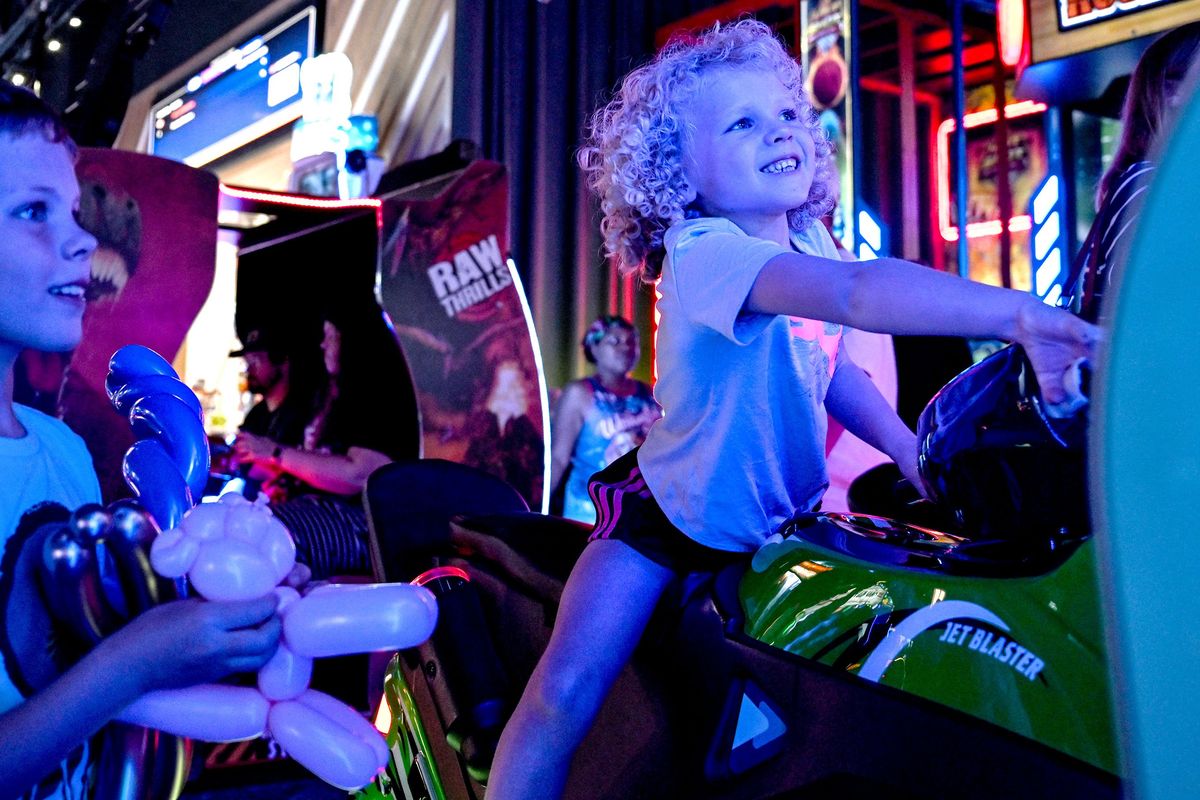 Six-year-old Charlotte Ferry plays Jet Blaster along with her brother Braden, 9, during the opening of Dave and Buster’s. (Kathy Plonka/The Spokesman-Review)