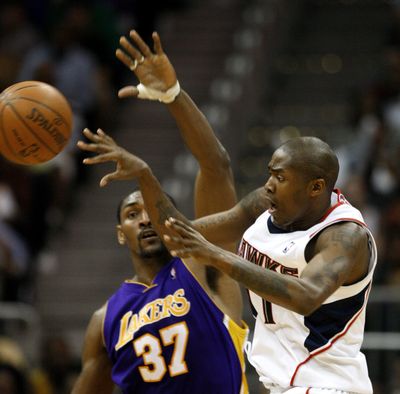 Atlanta’s Jamal Crawford fires a pass past Los Angeles defender Ron Artest during second-half play Wednesday in Atlanta. (Associated Press)