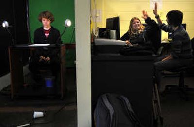 
Will Maupin, 16, studies his script while Lexi Bass, 16, high-fives Hannah Whitmore at the eMerge News headquarters last week. 
 (Photos by RAJAH BOSE / The Spokesman-Review)