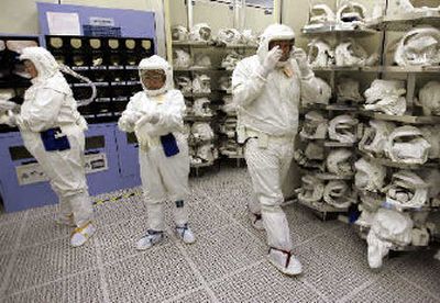 
Intel Corp. workers put on clean suits before working on chip manufacturing at Intel headquarters in Santa Clara, Calif., Intel Corp. said Tuesday a total of 10,500 jobs will be eliminated over the next year through layoffs, attrition and the sale of underperforming business groups as part of a massive restructuring
 (Associated Press / The Spokesman-Review)