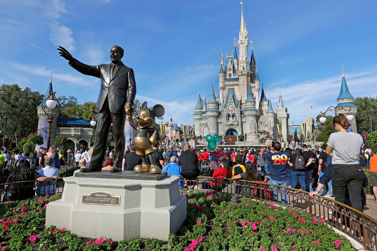 Guests watch a show near a statue of Walt Disney and Micky Mouse in front of the Cinderella Castle at the Magic Kingdom at Walt Disney World in Lake Buena Vista, Fla., on Jan. 9, 2019.  (John Raoux)