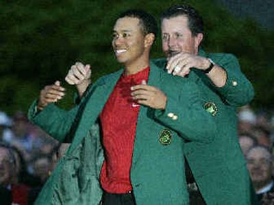 
Tiger Woods, left, gets the Green Jacket from Phil Mickelson.
 (Associated Press / The Spokesman-Review)