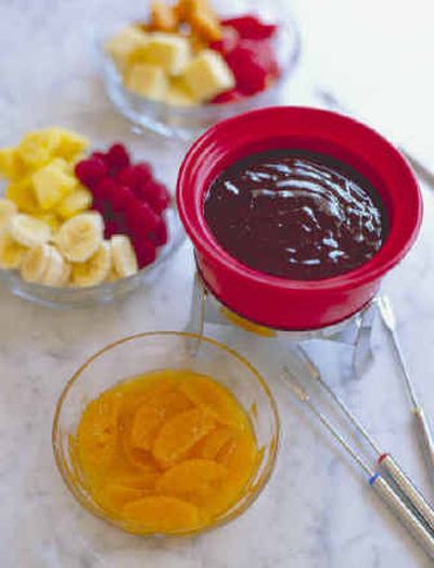 
A pot of Grand Marnier-Honey Chocolate Fondue is surrounded by fruit, cake cubes and other dipping delights. 
 (Associated Press / The Spokesman-Review)