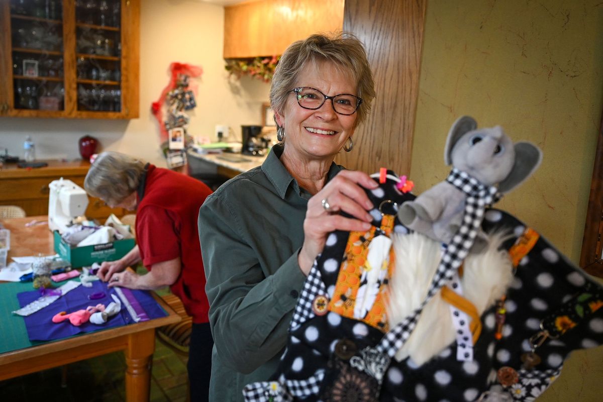 Spokane’s Fidget Project member Carol Becker shows off her elephant fidget quilt she made for her Uncle Melvin, as Elaine Hemingway works on her quilt at left.  (Dan Pelle/For The Spokesman-Review)