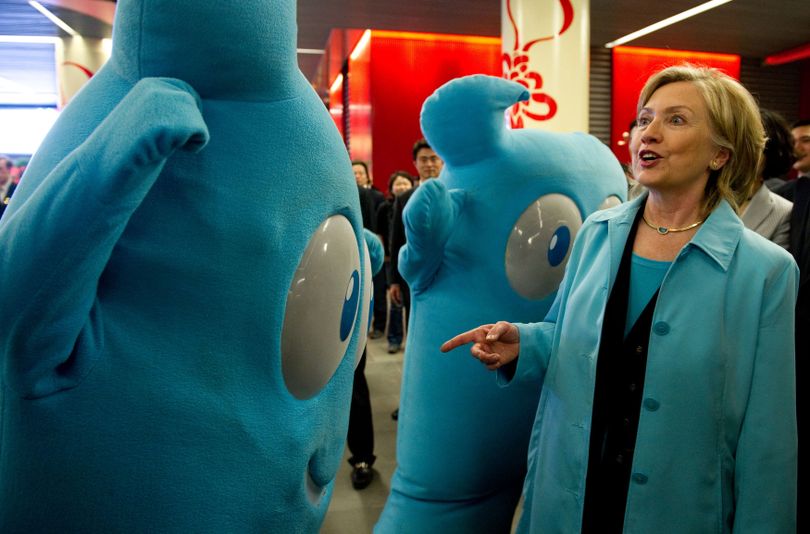 U.S. Secretary of State Hillary Rodham Clinton points out that she is wearing the same color as the mascot of the Shanghai World Expo 2010, named Haibao, while touring China's Pavilion in Shanghai, China Saturday, May 22, 2010. (Saul Loeb / Pool Afp)