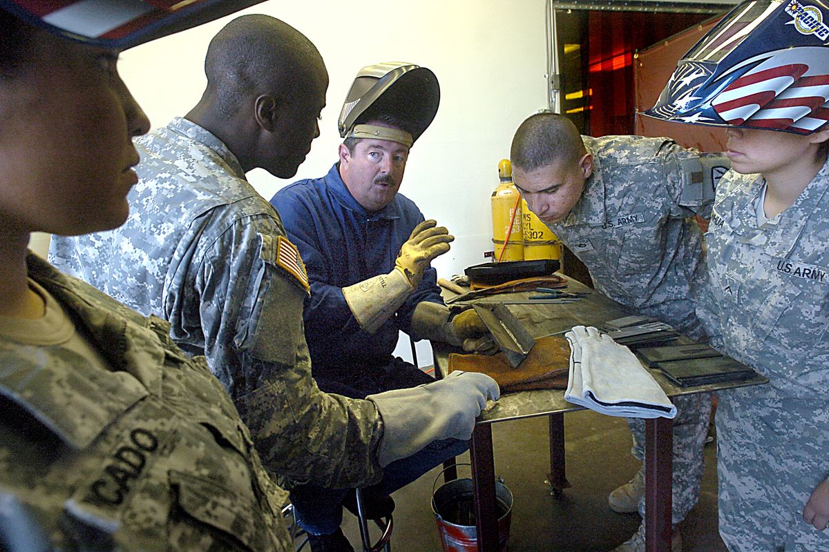 Kelly Hopkins, center, with Pacific Welding Supplies in Auburn, teaches soldiers from Fort Lewis’ 602nd Forward Support Company the basics of welding July 21. Associated Press photos (Associated Press photos / The Spokesman-Review)
