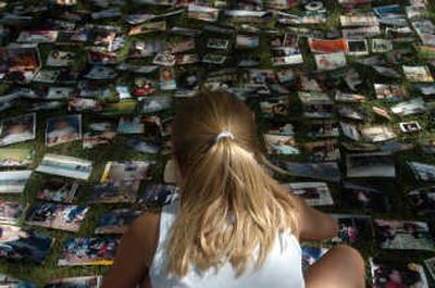 
A girl spreads out photos to dry in the front yard of Glen Cease's house after the pictures were damaged by a flood Sunday in Ottawa, Ohio. Associated Press
 (Associated Press / The Spokesman-Review)