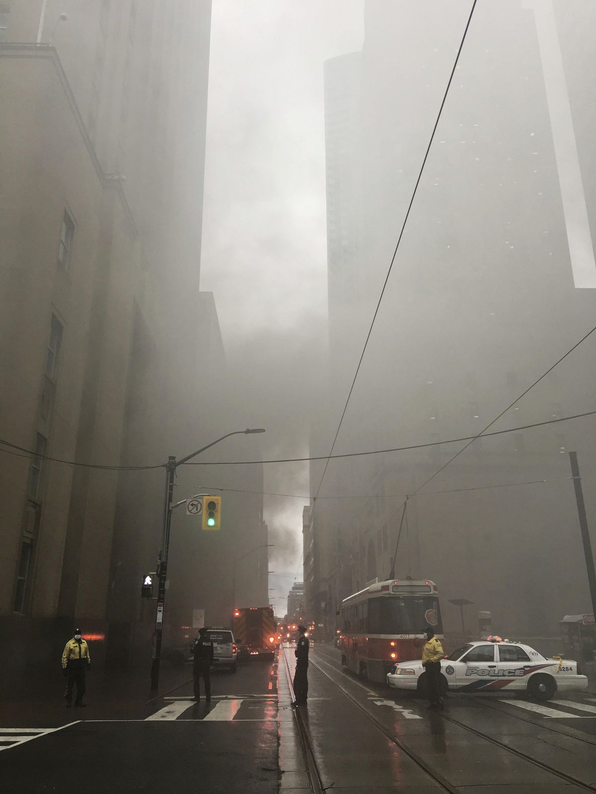 Police block the street as smoke pours into the air following a series of loud blasts were heard in Toronto on Monday, May 1, 2017. (Graeme Roy / The Canadian Press)