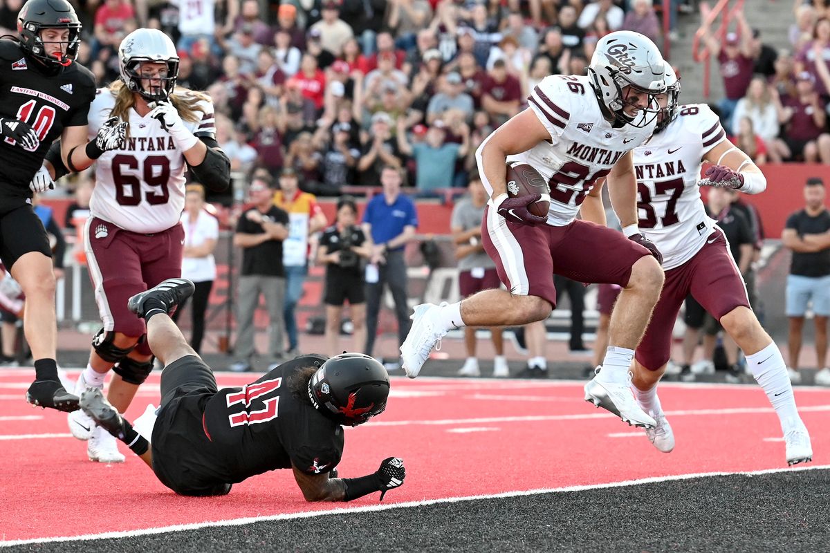 Montana running back Nick Ostmo jumps past Eastern Washington’s Samarai Anderson for a touchdown during Saturday’s Big Sky Conference game in Cheney.  (James Snook/For The Spokesman-Review)