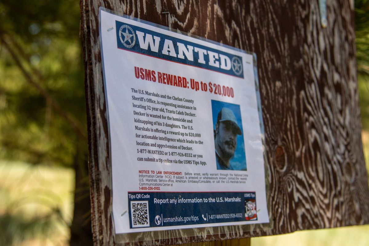 A wanted sign offering a reward for locating Travis Decker is posted on a tree near a trailhead in Washington’s Blewett Pass. (Alexandra Duggan / The Spokesman-Review)