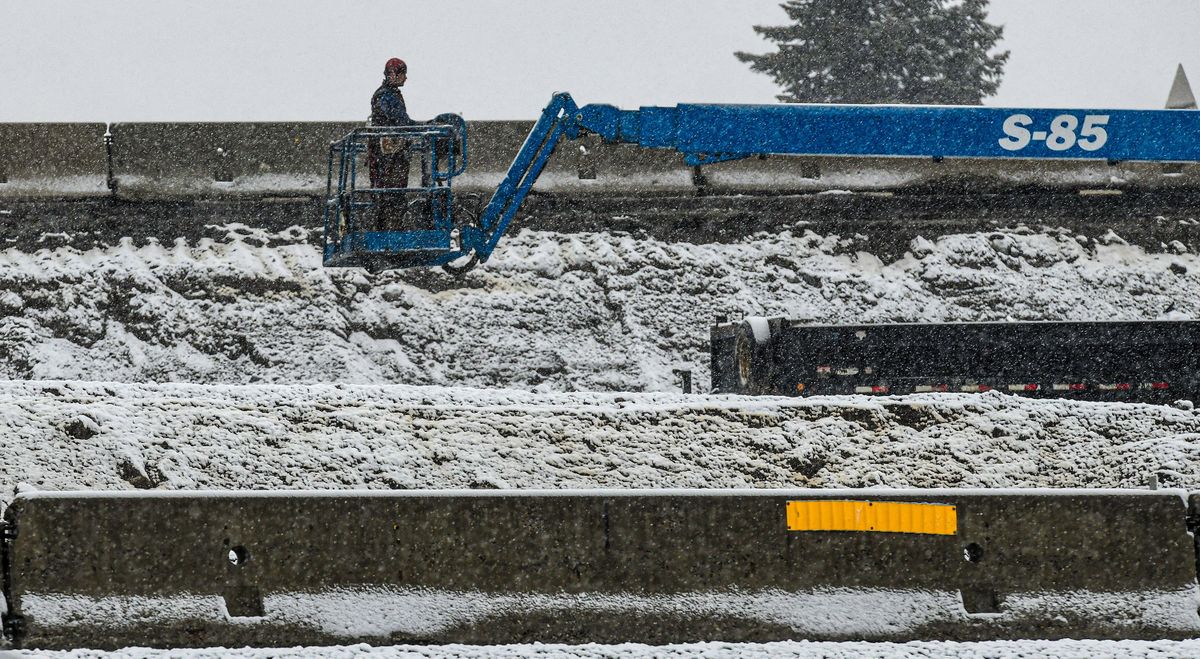 A construction worker braves the rain and snow on Friday in Post Falls.  (Kathy Plonka/The Spokesman-Review)