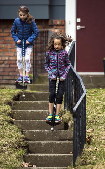 Next level: Best friends Grace Schneider, 10 (in back) and Anna Little, 10, pogo stick down the steps in Schneider’s front yard Friday on Spokane’s South Hill. The friends have been pogo sticking for two years, but recently discovered that they could bounce down stairs. (Colin Mulvany / The Spokesman-Review)